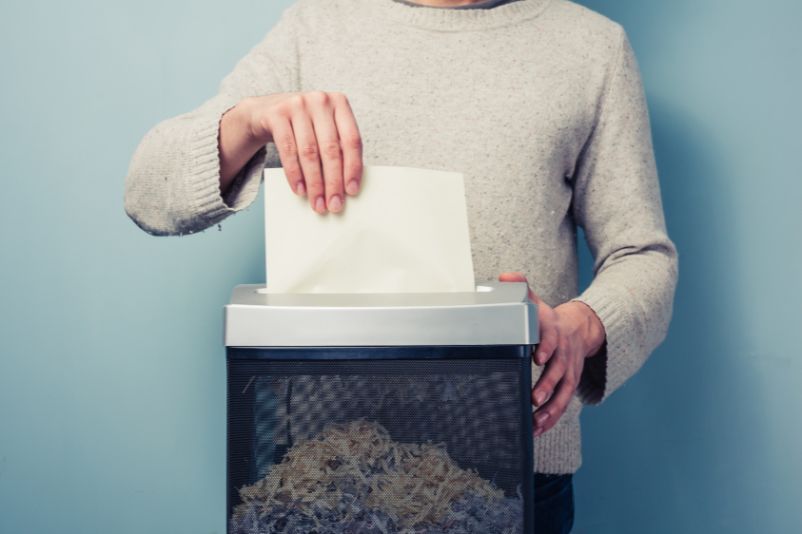 Person shredding their documents in a small shredder