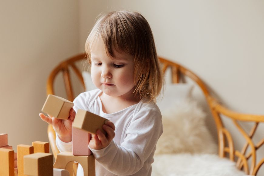 Young girl playing with toy blocks