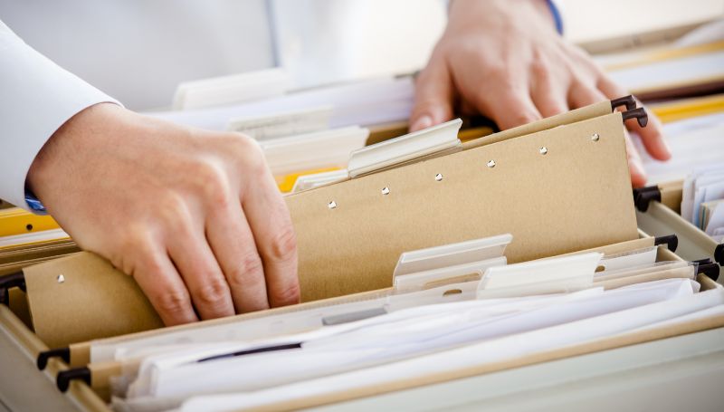 A close-up photograph of a person filing documents